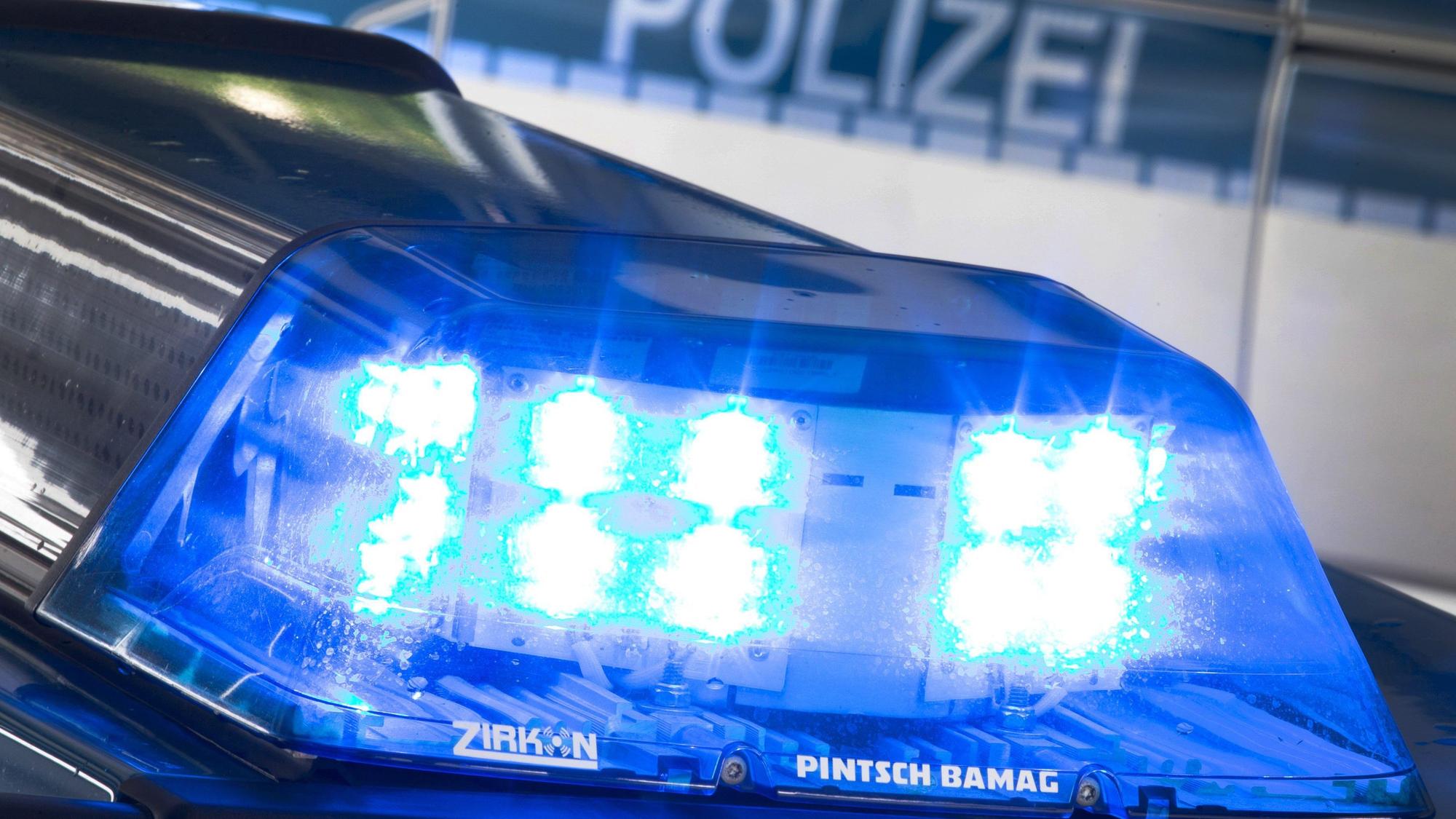 Ein Blaulicht leuchtet während eines Einsatzes auf dem Dach eines Polizeiwagens.