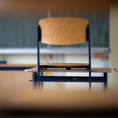 Ein Stuhl steht in einem Klassenzimmer einer Regelschule auf einem Tisch.