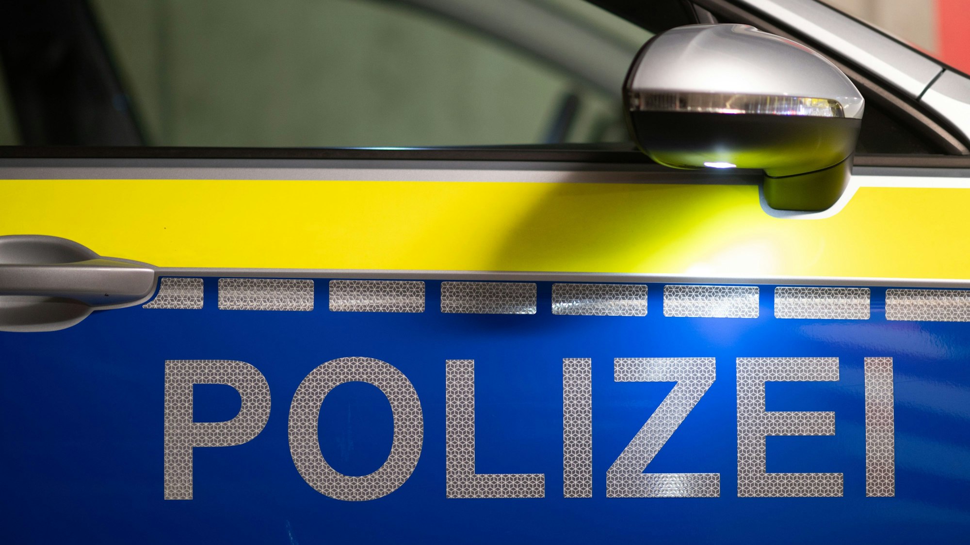 „Polizei“ ist auf der Tür eines Polizeiautos zu lesen.