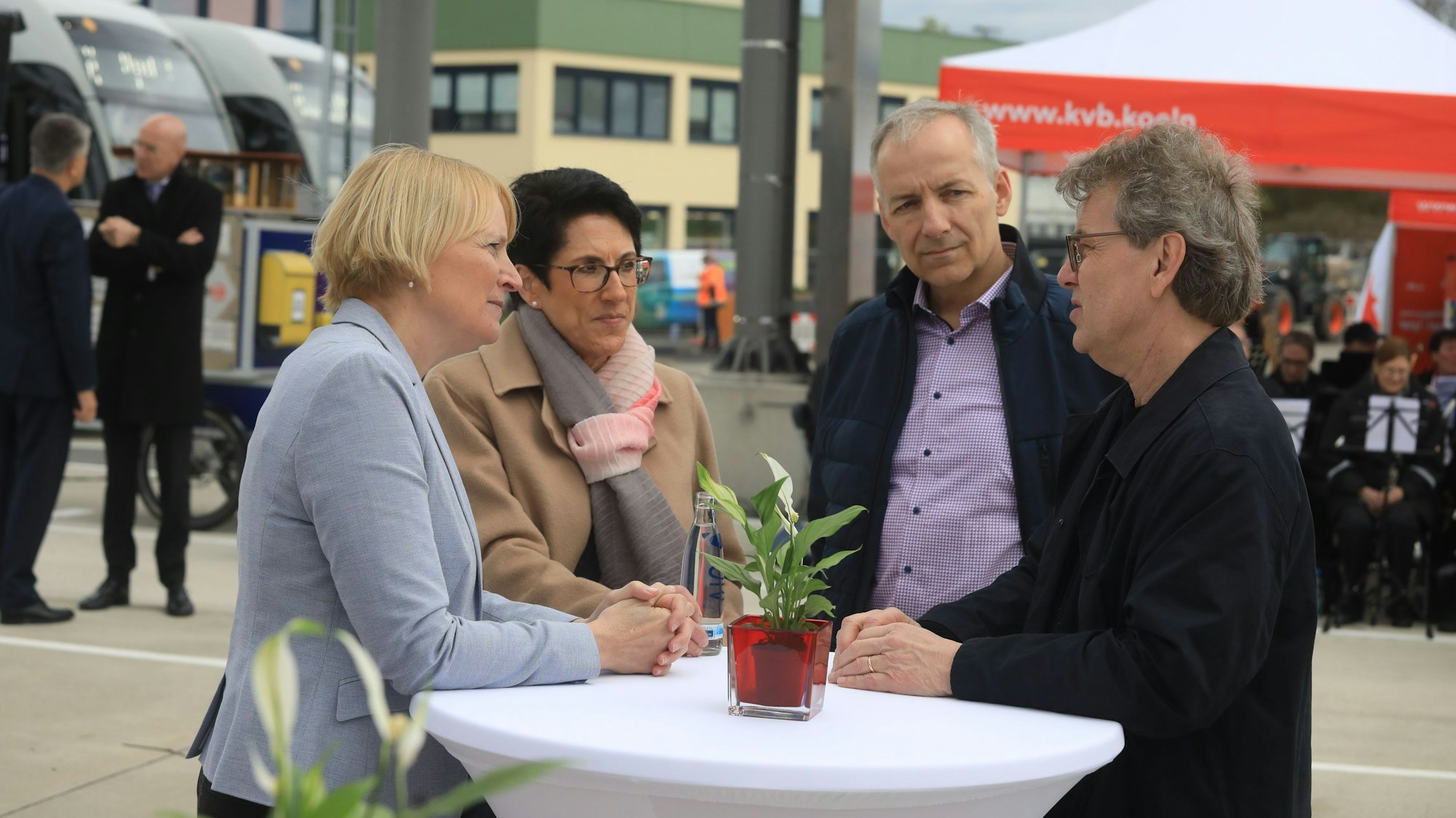 Zwei Frauen und zwei Männer stehen an einem Stehtisch.