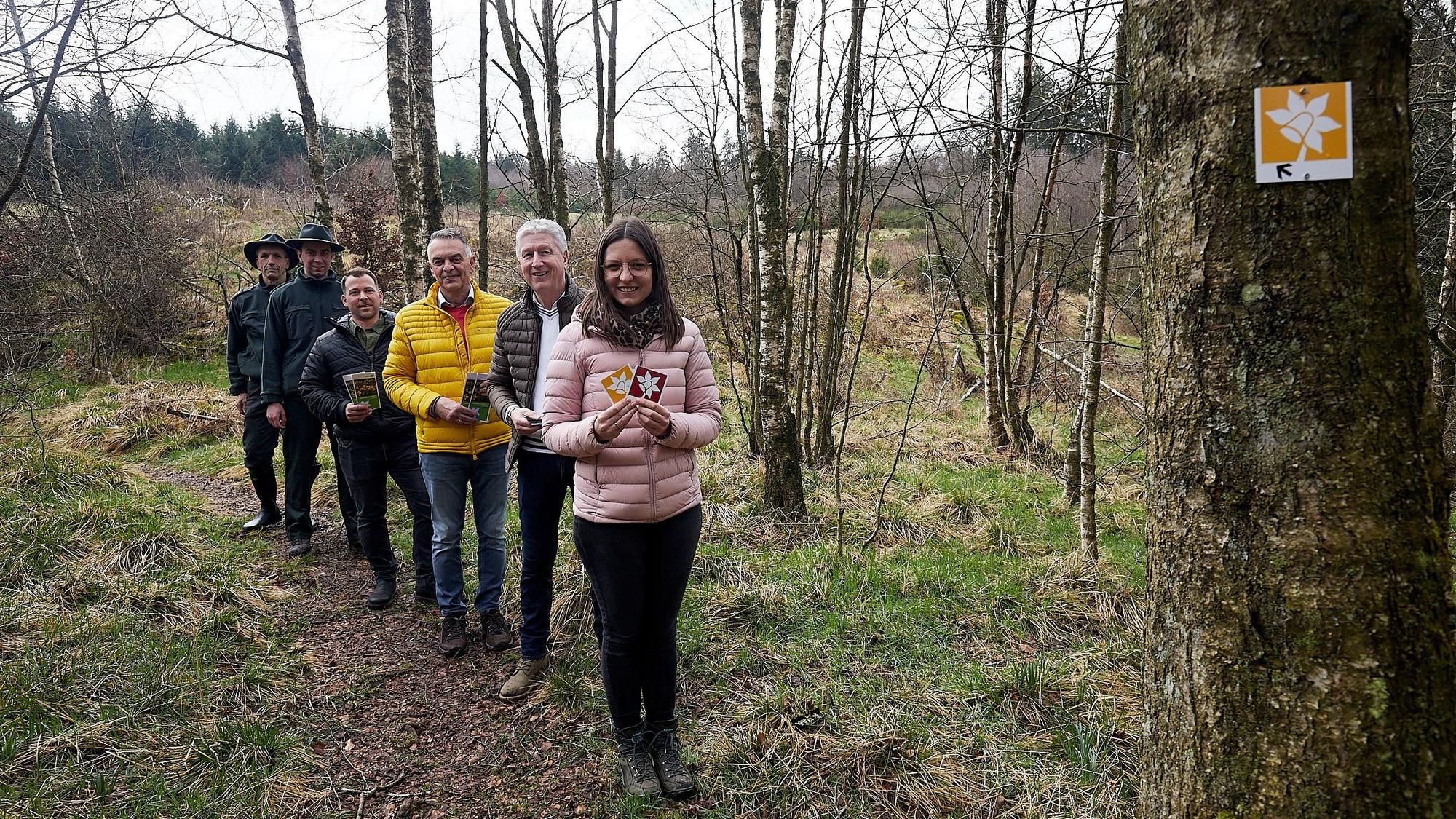 Die Gruppe ist in einer Reihe auf dem schmalen Narzissenwanderweg unterwegs.