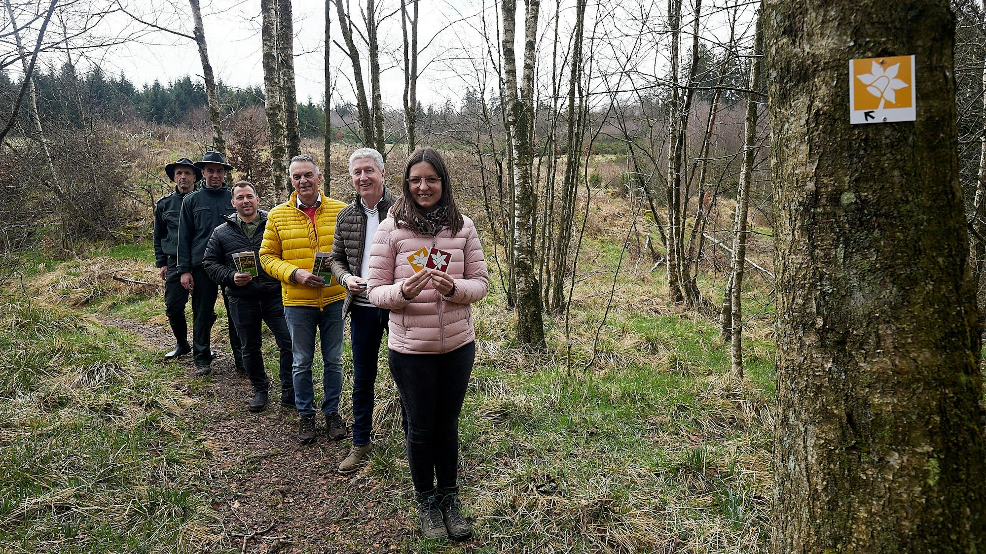 Die Gruppe ist in einer Reihe auf dem schmalen Narzissenwanderweg unterwegs.