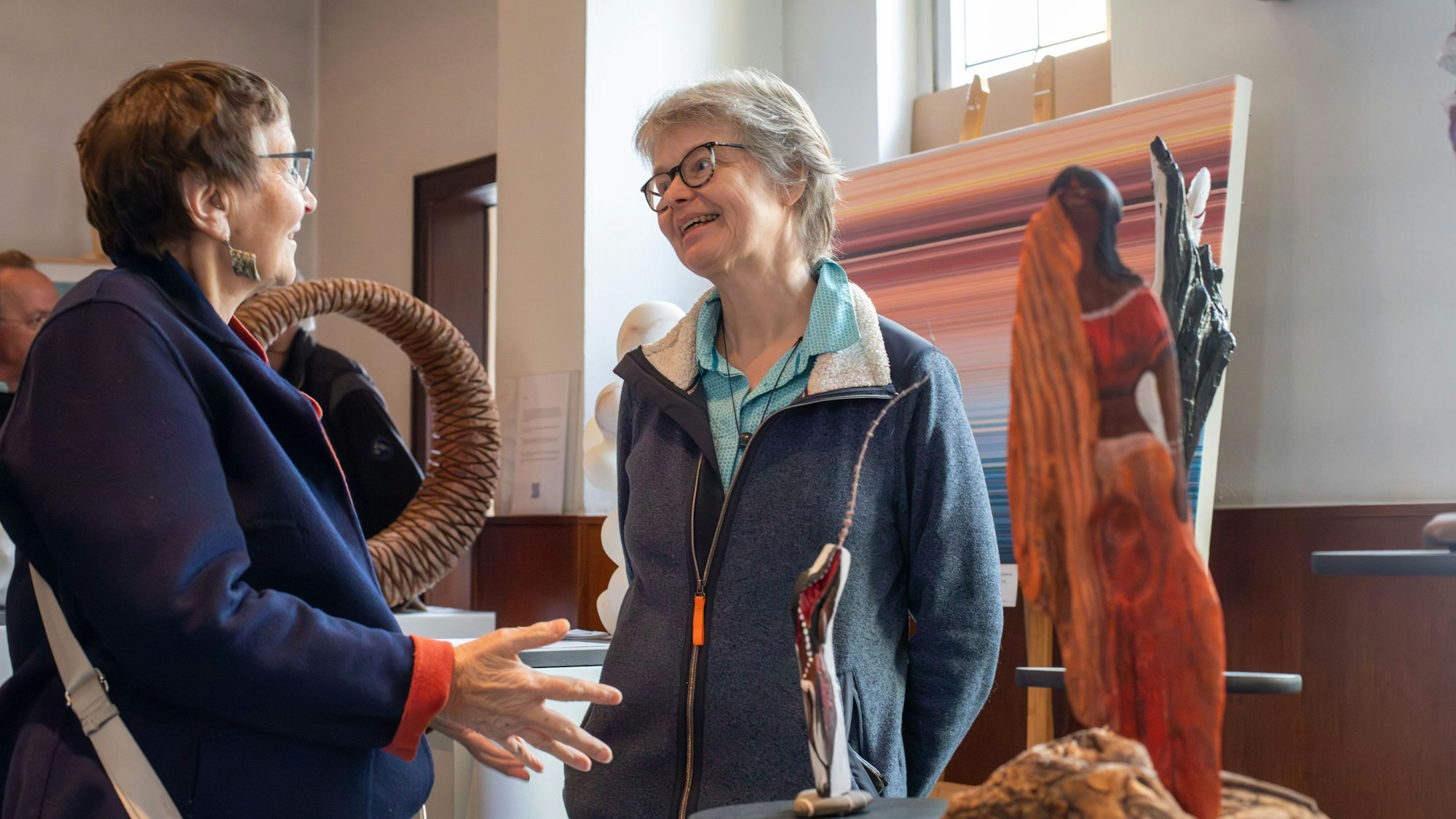 Zwei Frauen stehen sich im angeregten Gespräch gegenüber.