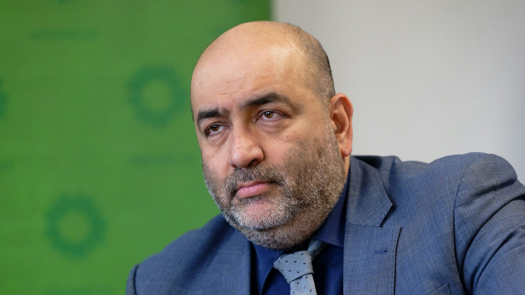 Der Grünen-Vorsitzende Omid Nouripour blickt bei einer Pressekonferenz vor eine Wand mit Logos der Partei ins Publikum.