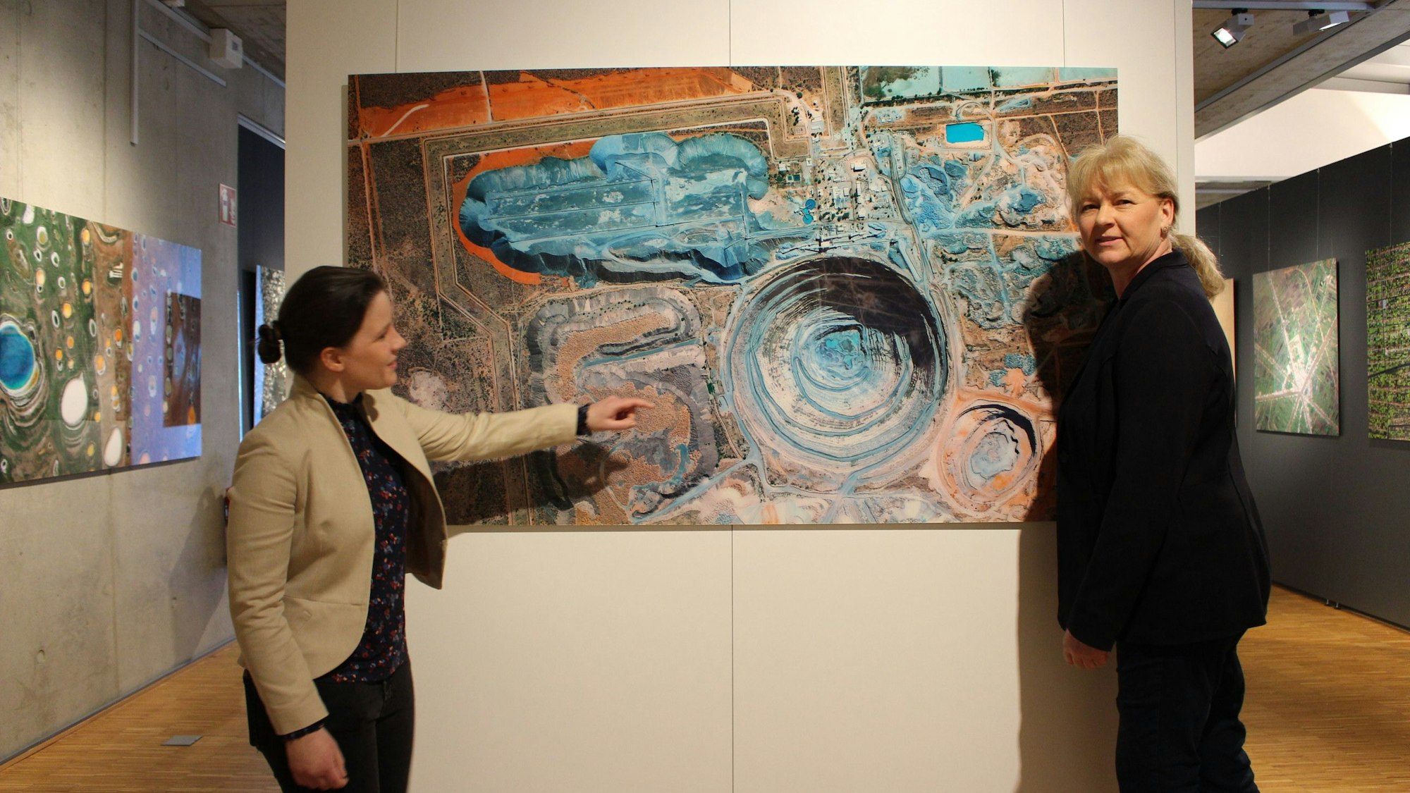 Dr. Heike Lützenkirchen und Maja Kützemeier vor dem Bild, das die Mine zeigt.