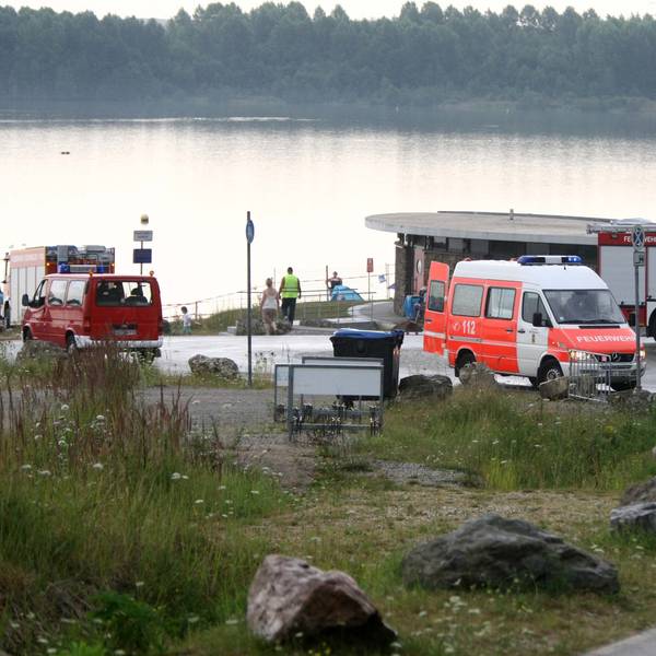 Polizei und Rettungsfahrzeuge am Blausteinsee im nordrhein-westfälischen Eschweiler. Kurz zuvor war eine Leiche aus dem Badesee gezogen worden. (Archivbild)