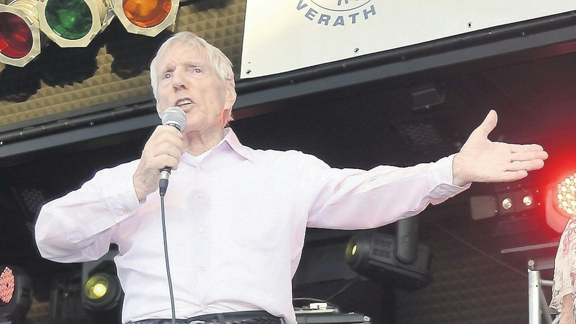 Hans Blum alias Henry Valentino steht auf einer Bühne und singt.