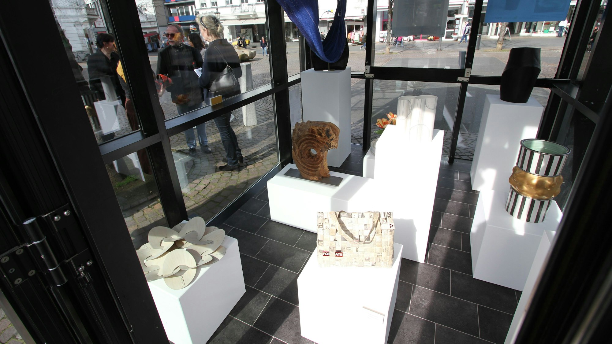 Kunstgegenstände aus Holz, Papier und Keramik in einem Glaspavillon