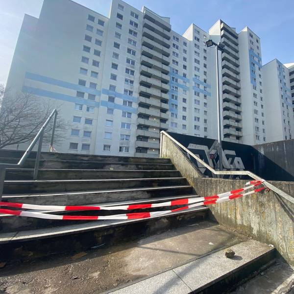 Auf dem Bild ist eine abgesperrte Treppe vor einer Wohnanlage zu sehen.