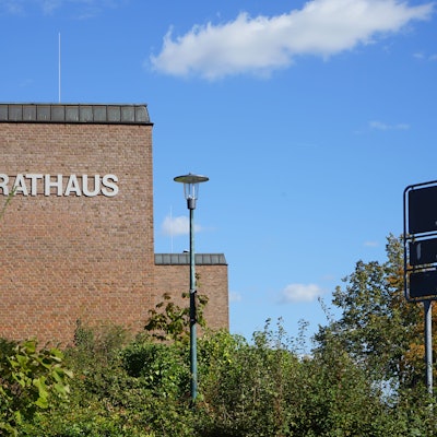 Zu sehen ist das Gebäude des Rathauses, das Gebäude besteht aus rötlichen Backsteinen.