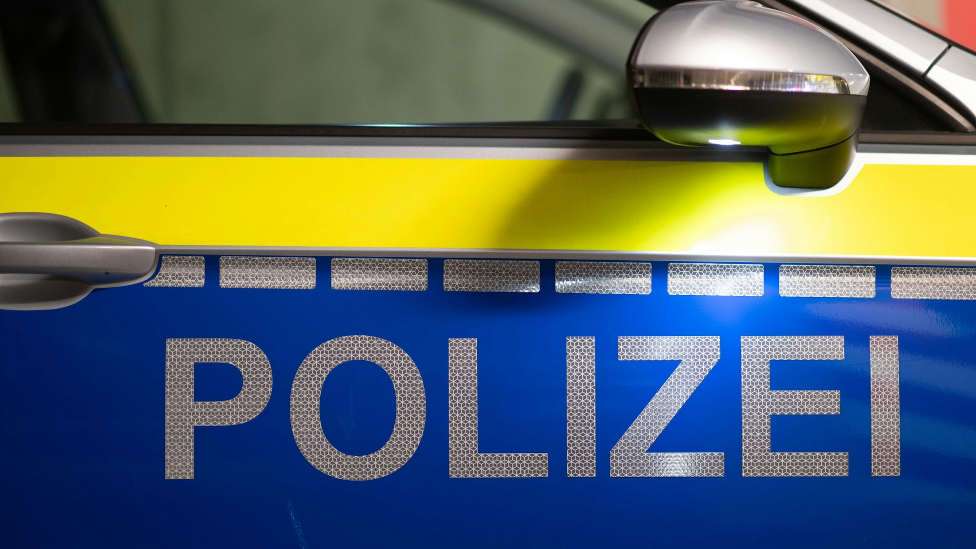 „Polizei“ ist auf der Tür eines Polizeiautos zu lesen.