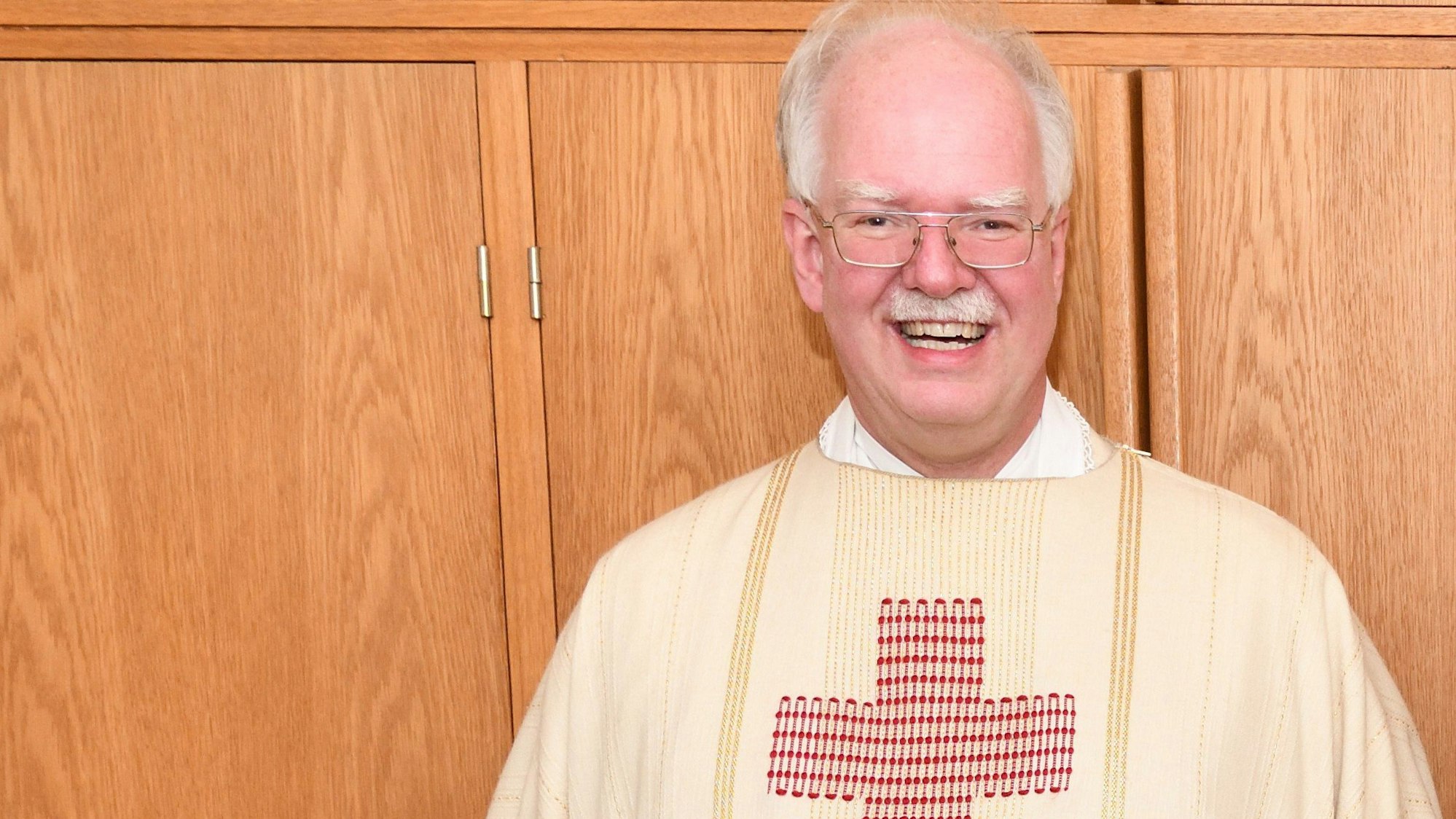 Zu sehen ist ein Pfarrer