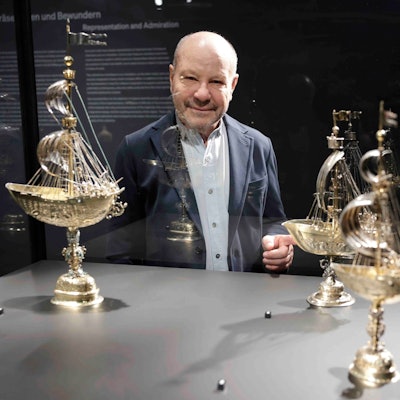 Sammler Thomas Olbricht vor einer Armada Trinkgefäße in Schiffsform.