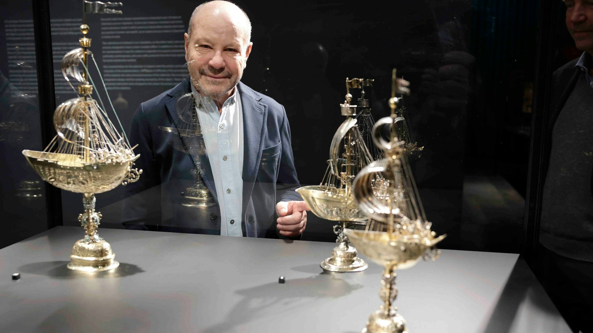 Sammler Thomas Olbricht vor einer Armada Trinkgefäße in Schiffsform.