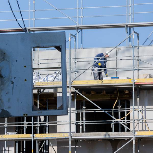 Köln: Eine massive Betonwand aus Stahlbeton wird mit einem Kran auf den zweiten Stock eines Rohbaus für Mietwohnungen im Stadtteil Ehrenfeld gehoben.