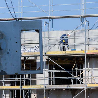 Köln: Eine massive Betonwand aus Stahlbeton wird mit einem Kran auf den zweiten Stock eines Rohbaus für Mietwohnungen im Stadtteil Ehrenfeld gehoben.