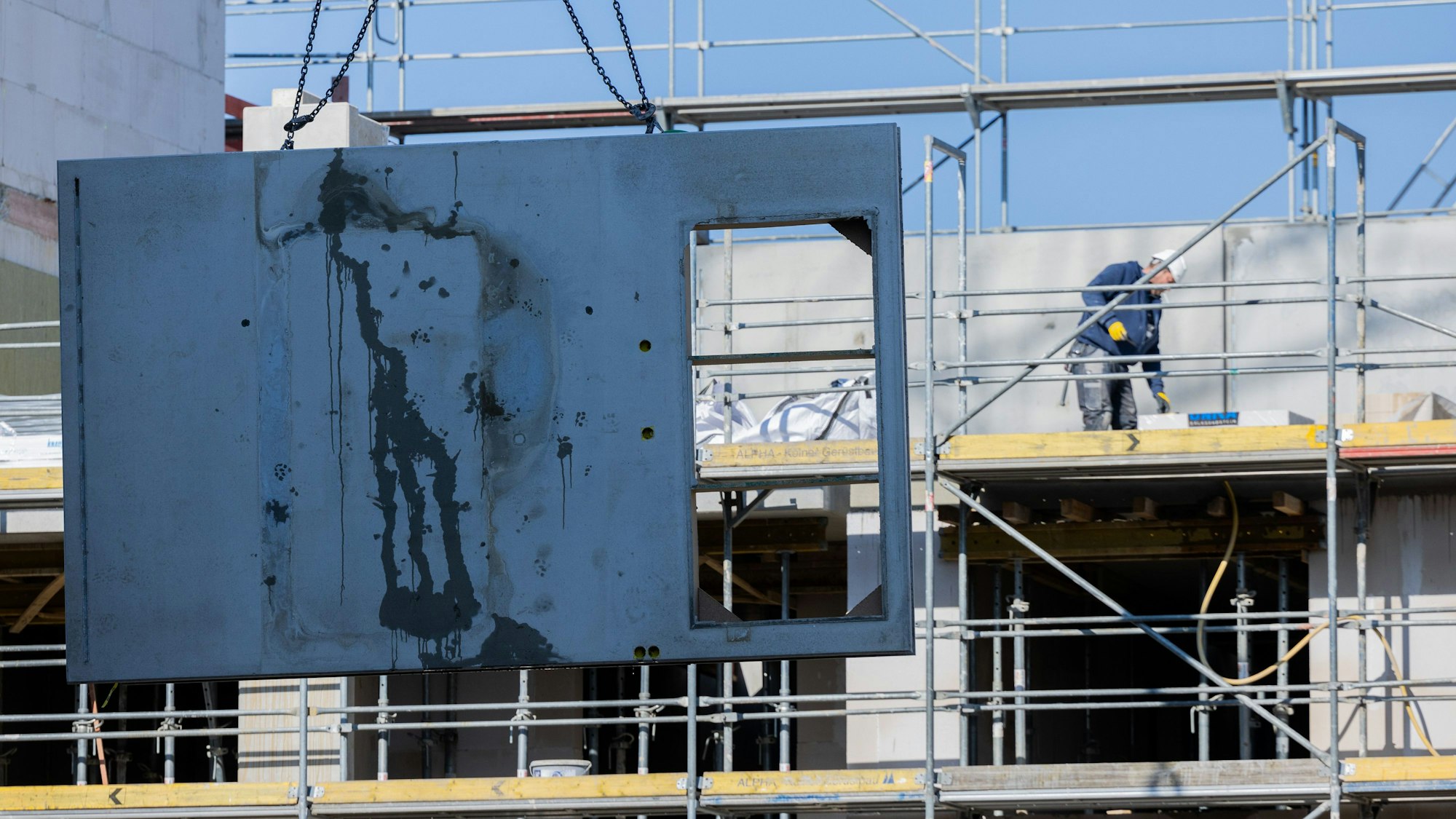 Köln: Eine massive Betonwand aus Stahlbeton wird mit einem Kran auf den zweiten Stock eines Rohbaus für Mietwohnungen im Stadtteil Ehrenfeld gehoben.
