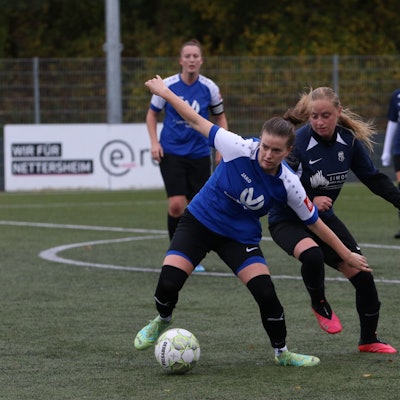 Das Bild zeigt Hannah Hamacher im Zweikampf mit einer Gegenspielerin.