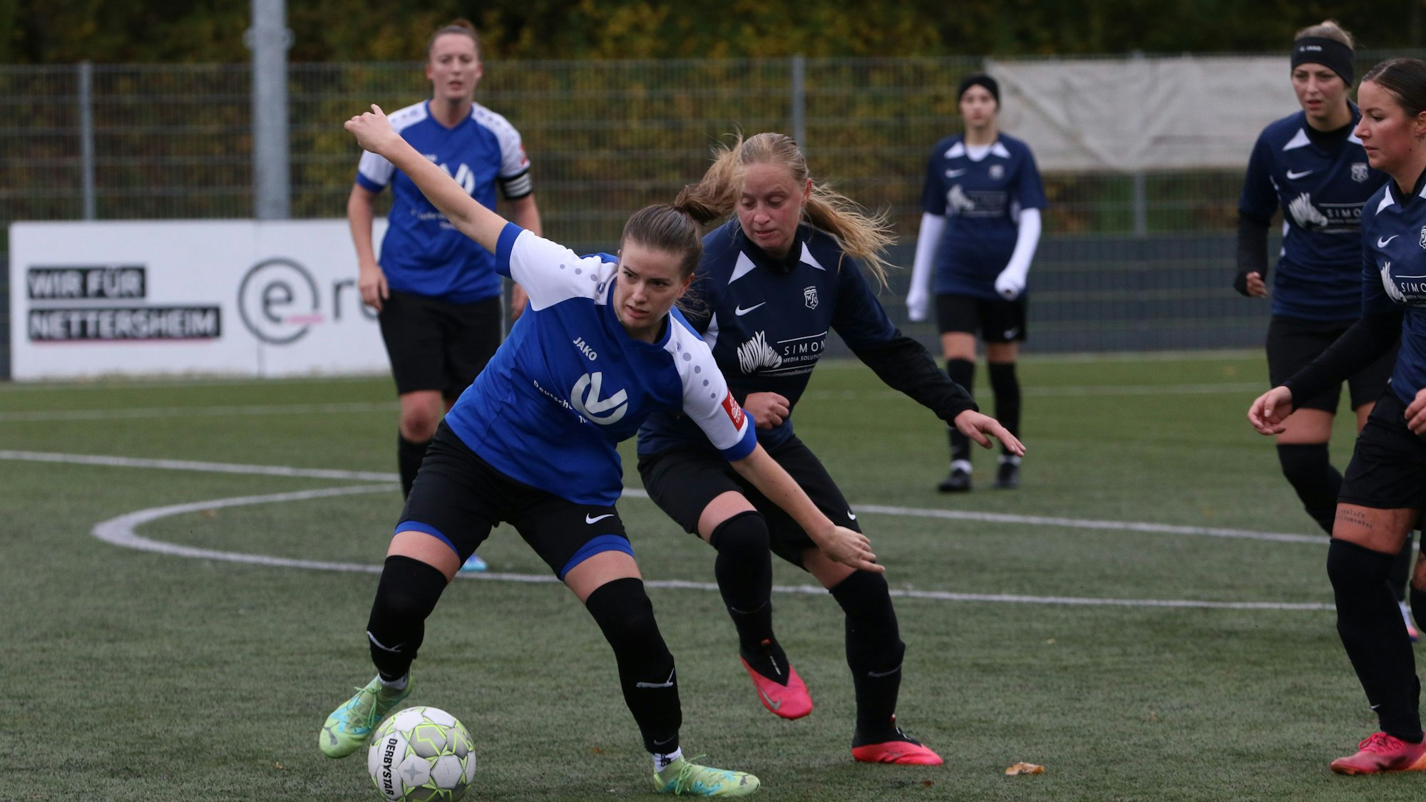 Das Bild zeigt Hannah Hamacher im Zweikampf mit einer Gegenspielerin.