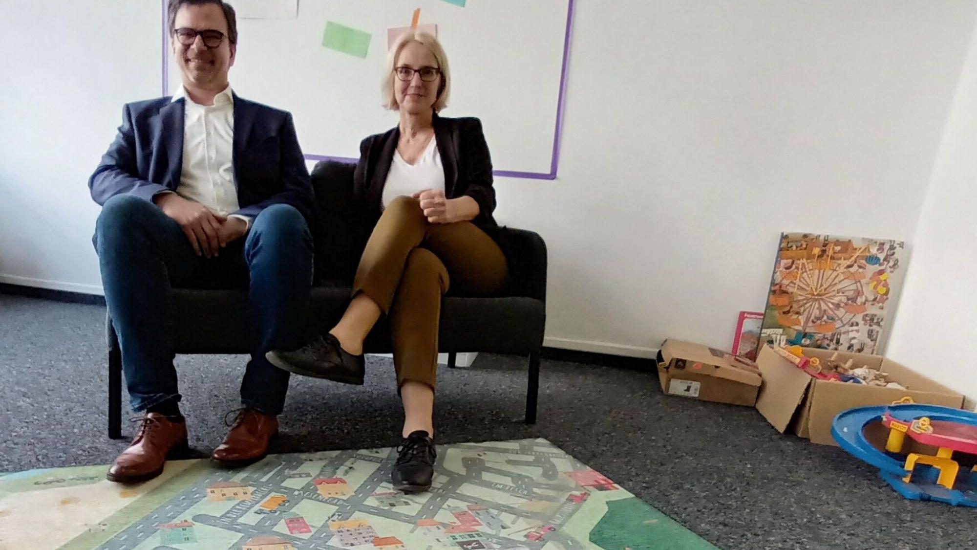 Eine Frau und ein Man sitzen auf einem Sofa