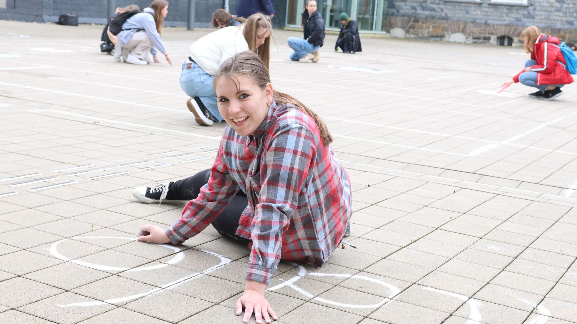Schülerin Lilly (15) von der städtischen Gesamtschule gehörte zu der Gruppe, die am Donnerstag im Waldbröler Bürgerdorf am Alsberg ein „Pac-Man“-Spiel mit Kreise aufs Pflaster gebracht hat.