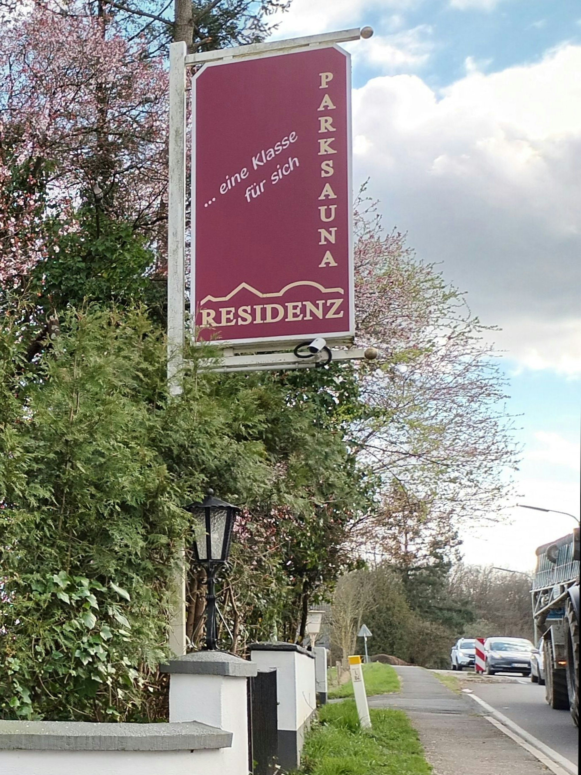 Ein Schild hängt an einem Pfahl an einer Straße
