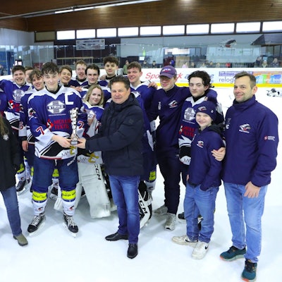 Während sich im Hintergrund die U17-Mannschaft der Wiehl Penguins aufgestellt hat, übergibt Bürgermeister Ulrich Stücker im Vordergrund den Meisterpokal an den Kapitän.