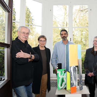 Eine Gruppe steht im Halbkreis um ein Kunstobjekt.