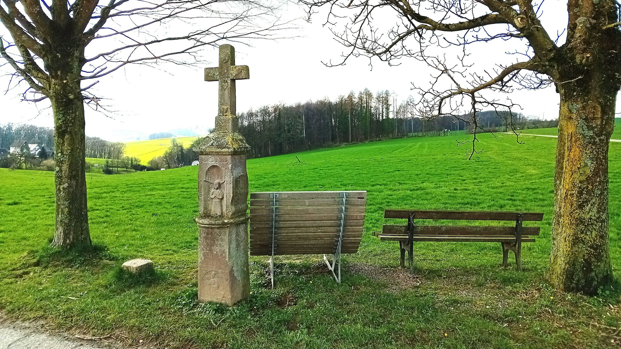 Ein Wegekreuz vor Panoramablick.