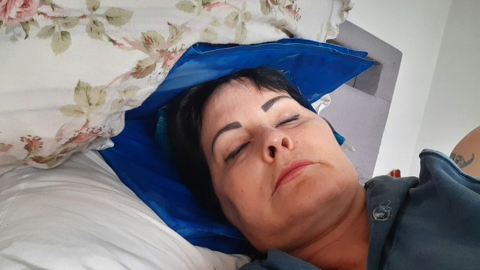 Saskia Jung liegt mit einem Kühl-Akku auf dem Kopf im Bett.