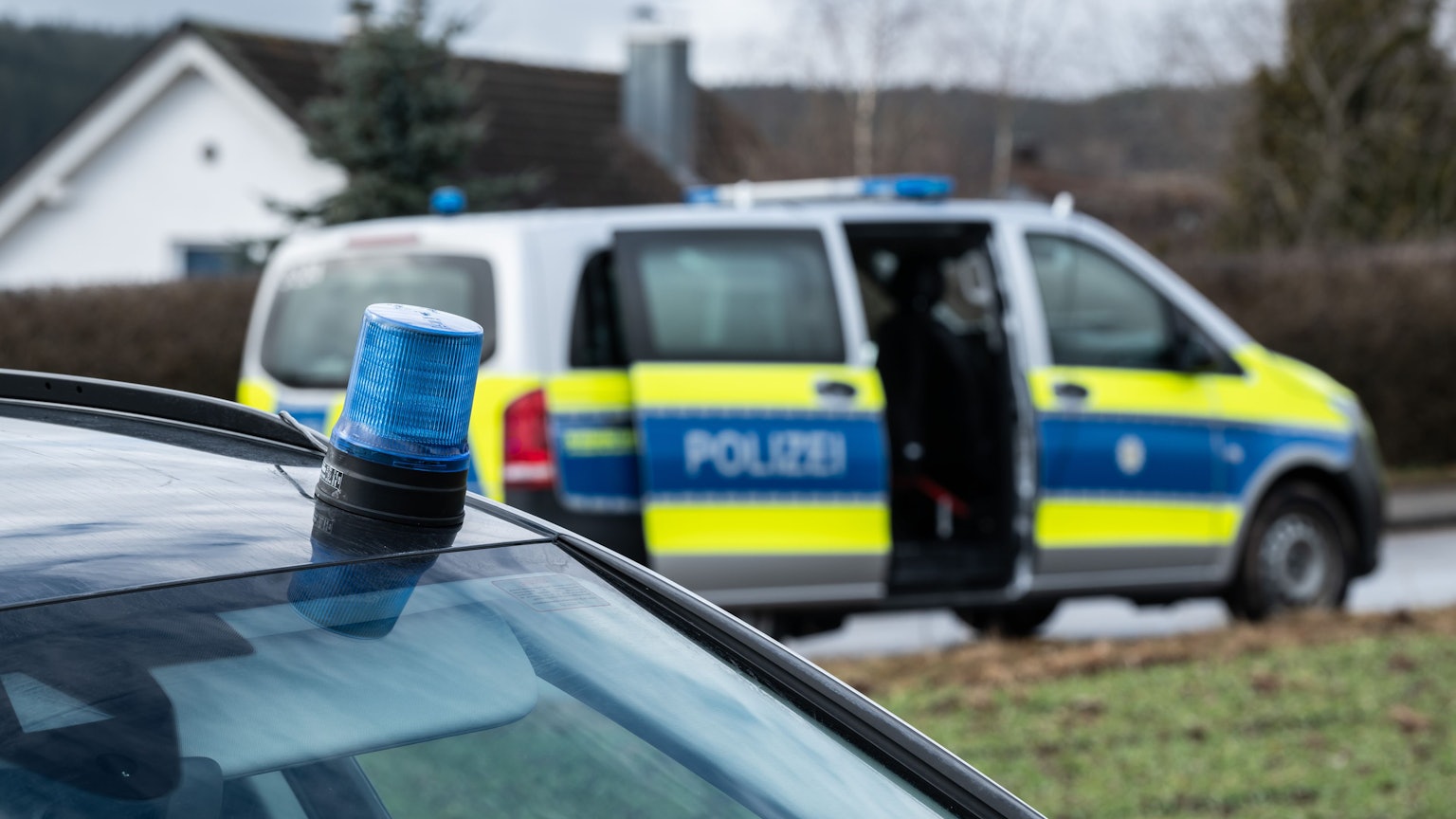 Einsatzfahrzeuge der Polizei stehen mit Blaulicht bei einem Wohngebiet (Symbolfoto).