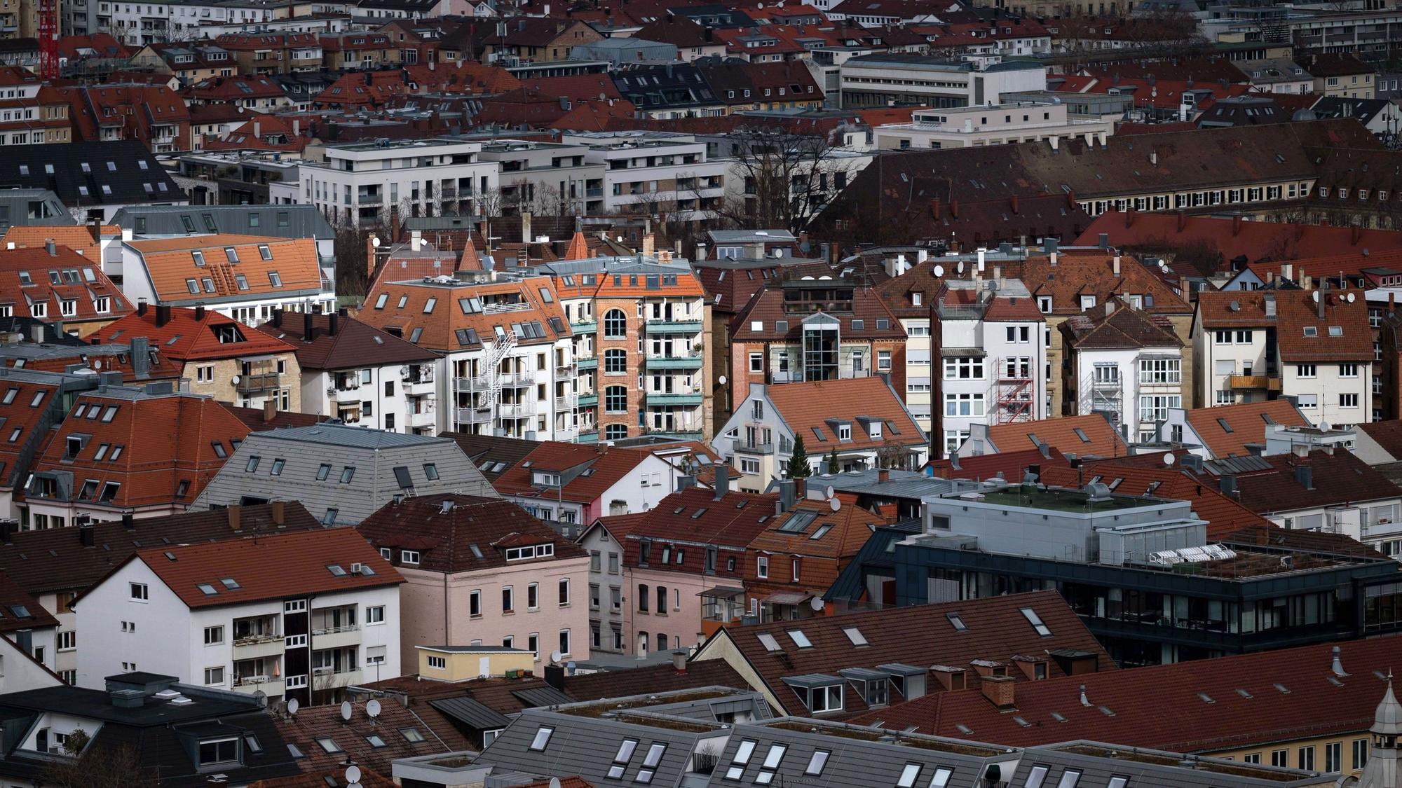 Vereinzelte Gebäude werden in der Stuttgarter Innenstadt durch ein Wolkenloch von der Sonne angestrahlt.