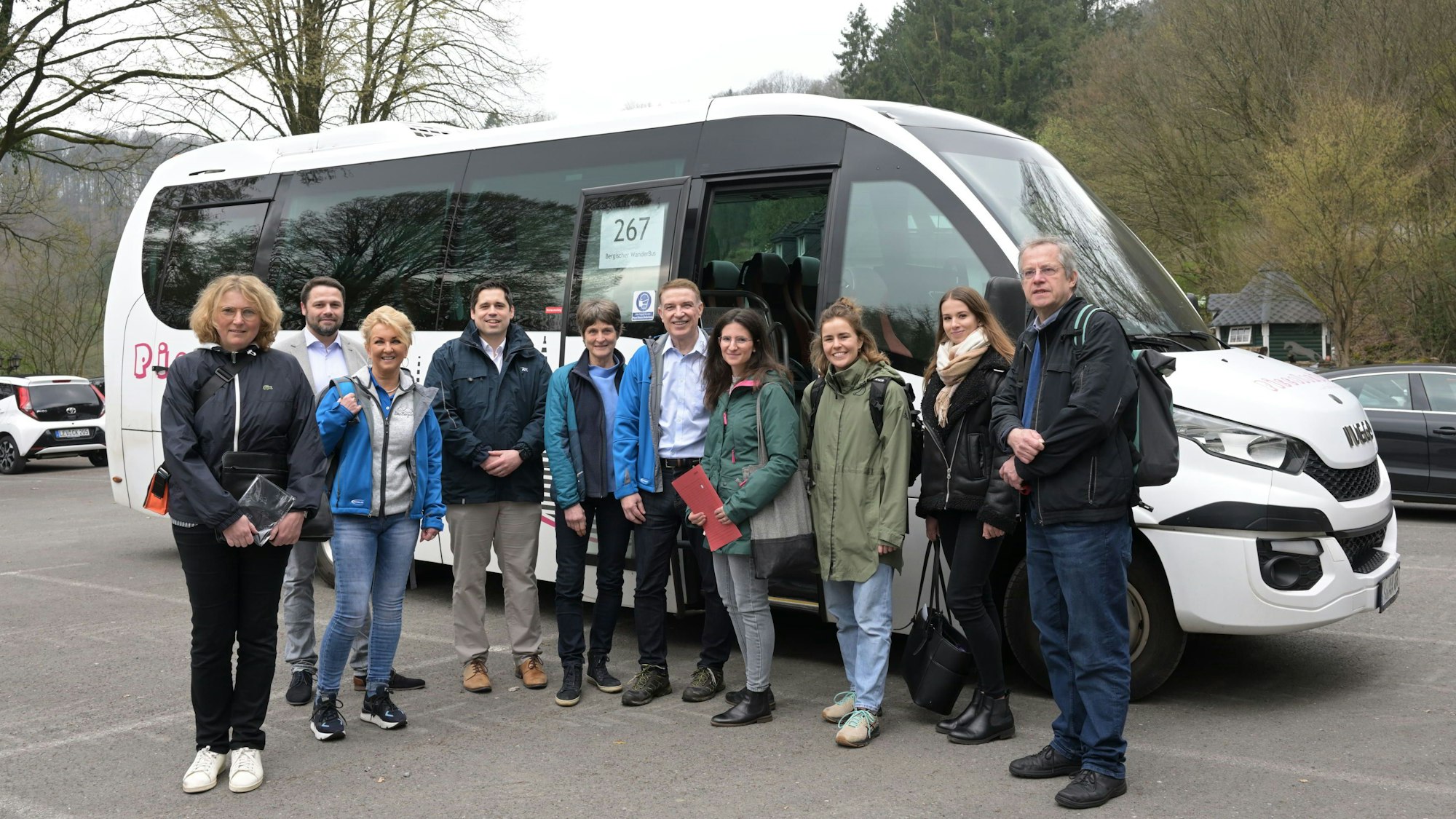 Menschen stehen vor dem Bergischen Wanderbus auf dem Parkplatz Am Rösberg in Odenthal-Altenberg.