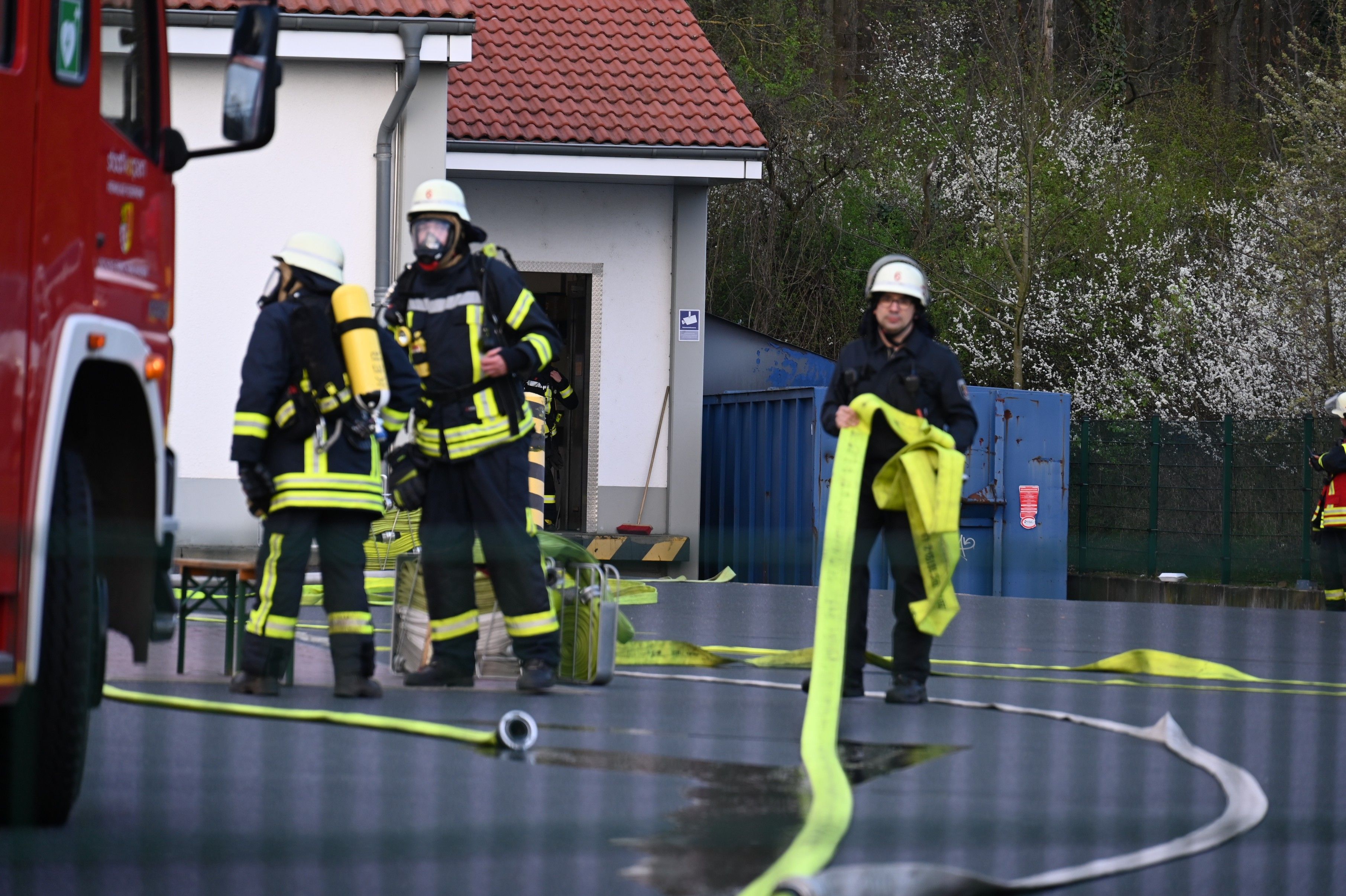 Es sind mehrere Feuerwehrleute zu sehen, die vor dem Discounter stehen.