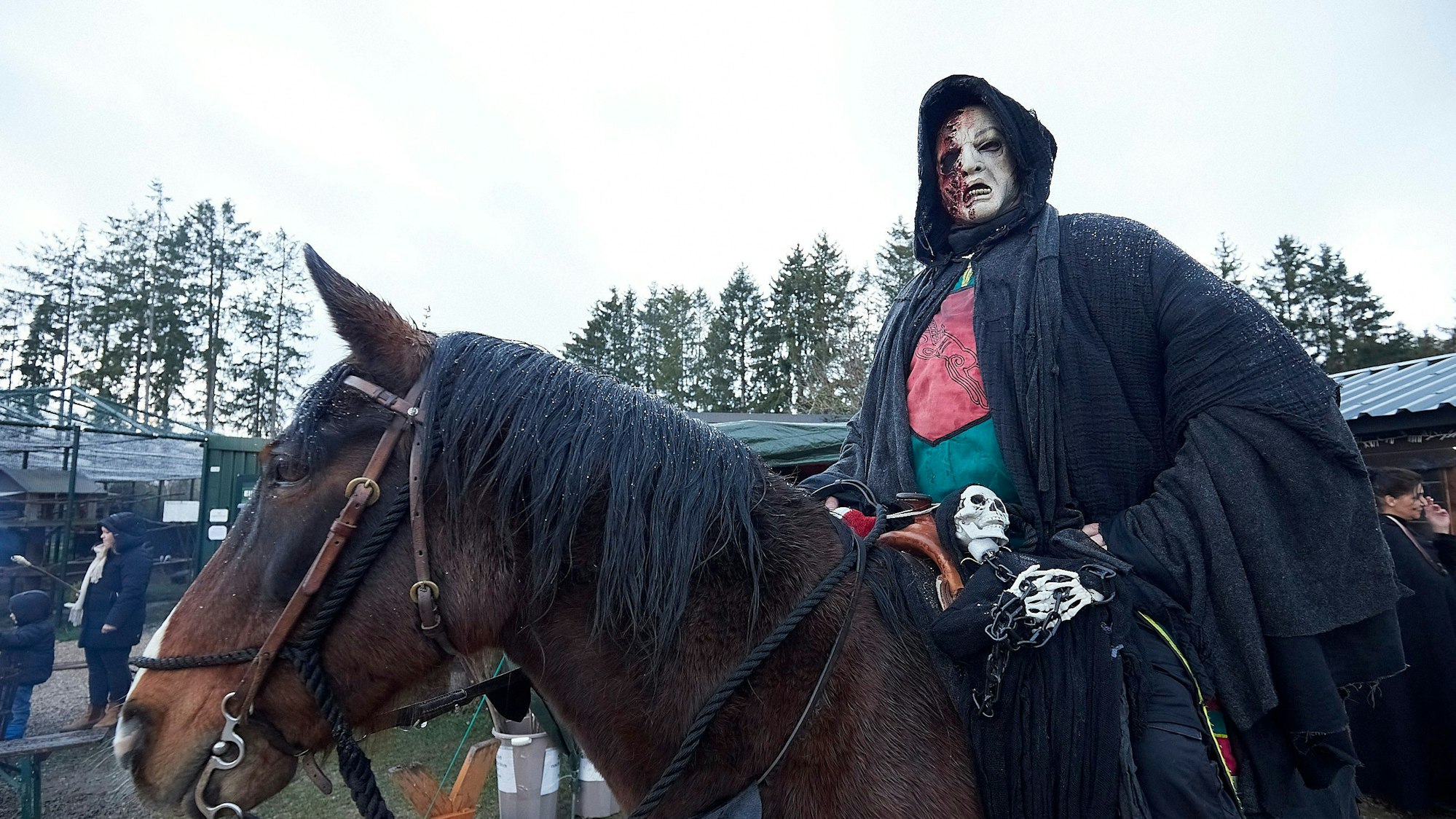 Hermann Klinkhammer sitzt als Geist verkleidet mit einem Umhang auf einem Pferd.