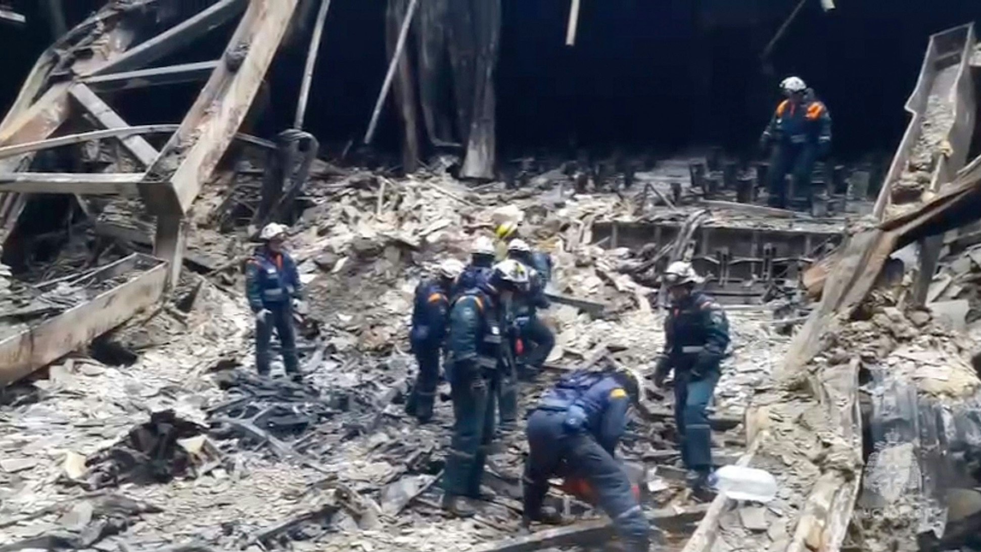 In this photo taken from video released by Russian Emergency Ministry Press Service on Sunday, March 24, 2024, rescuers work in the burned concert hall after a terrorists attack on the building of the Crocus City Hall on the western edge of Moscow, Russia. Russia's top state investigative agency says the death toll in the Moscow concert hall attack has risen to 133. The attack Friday on Crocus City Hall, a sprawling mall and concert venue on Moscow's western edge, also left many wounded and left the building a smoldering ruin. (Russian Emergency Ministry Press Service via AP)