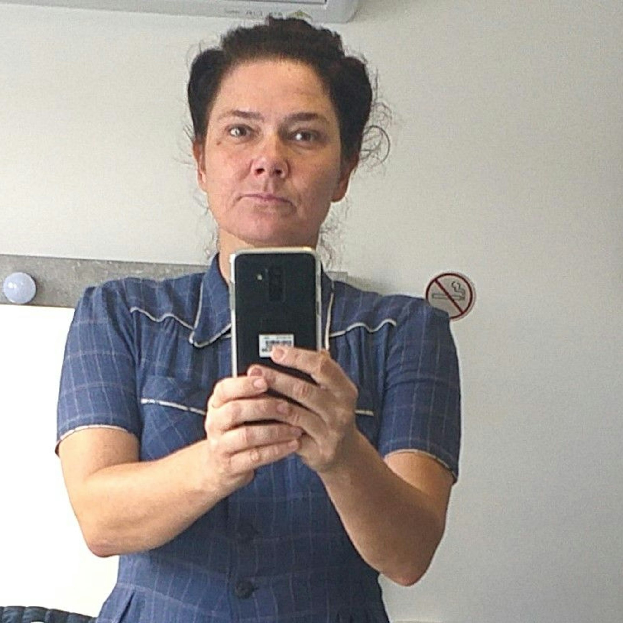 Medusa Knopf macht am Set ein Selfie mit ihrem Handy.