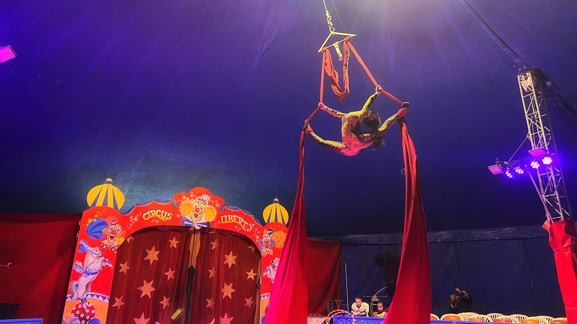 Zwei Artisten schweben unter dem Zirkuszelt.