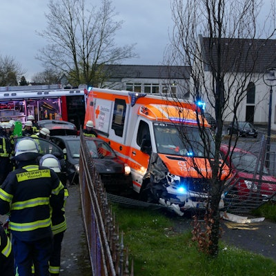 Zwei Autos und ein Rettungswagen haben einen Zaun durchbrochen.