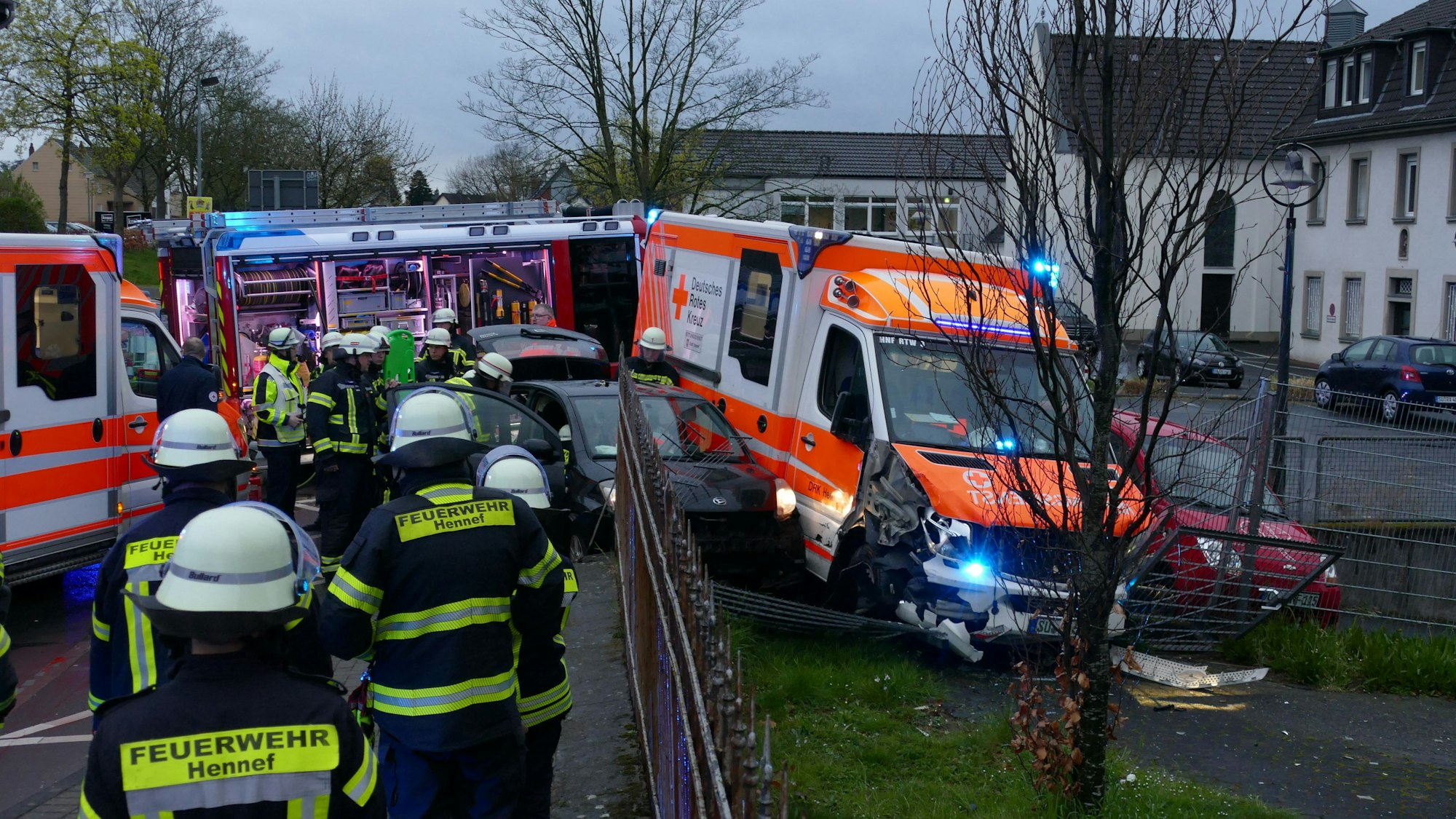 Zwei Autos und ein Rettungswagen haben einen Zaun durchbrochen.