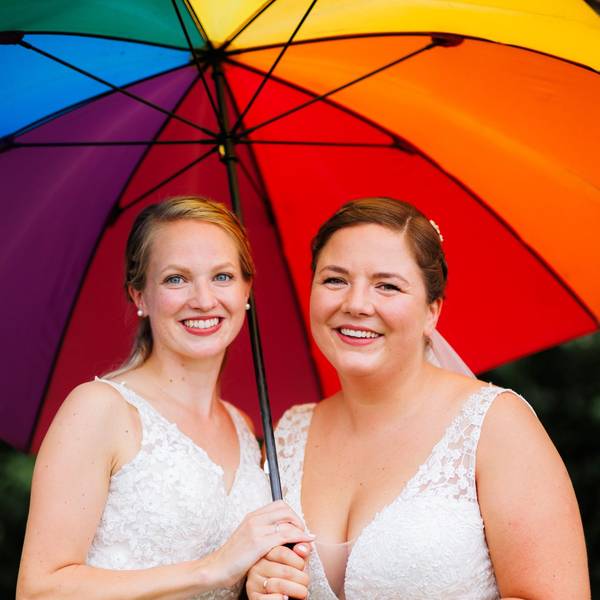 Laura und Christel Wendeler halten einen Regenbogen-Regenschirm.
