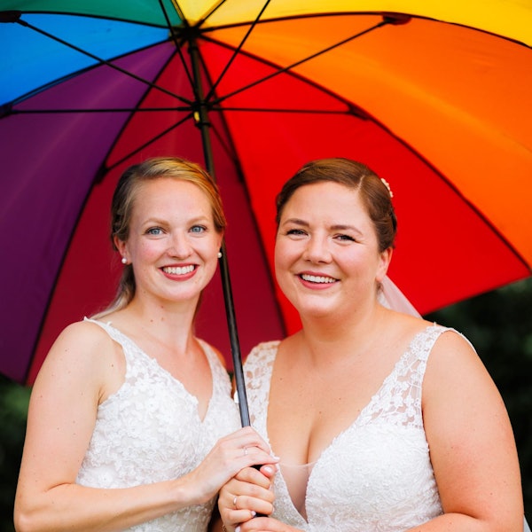 Laura und Christel Wendeler halten einen Regenbogen-Regenschirm.
