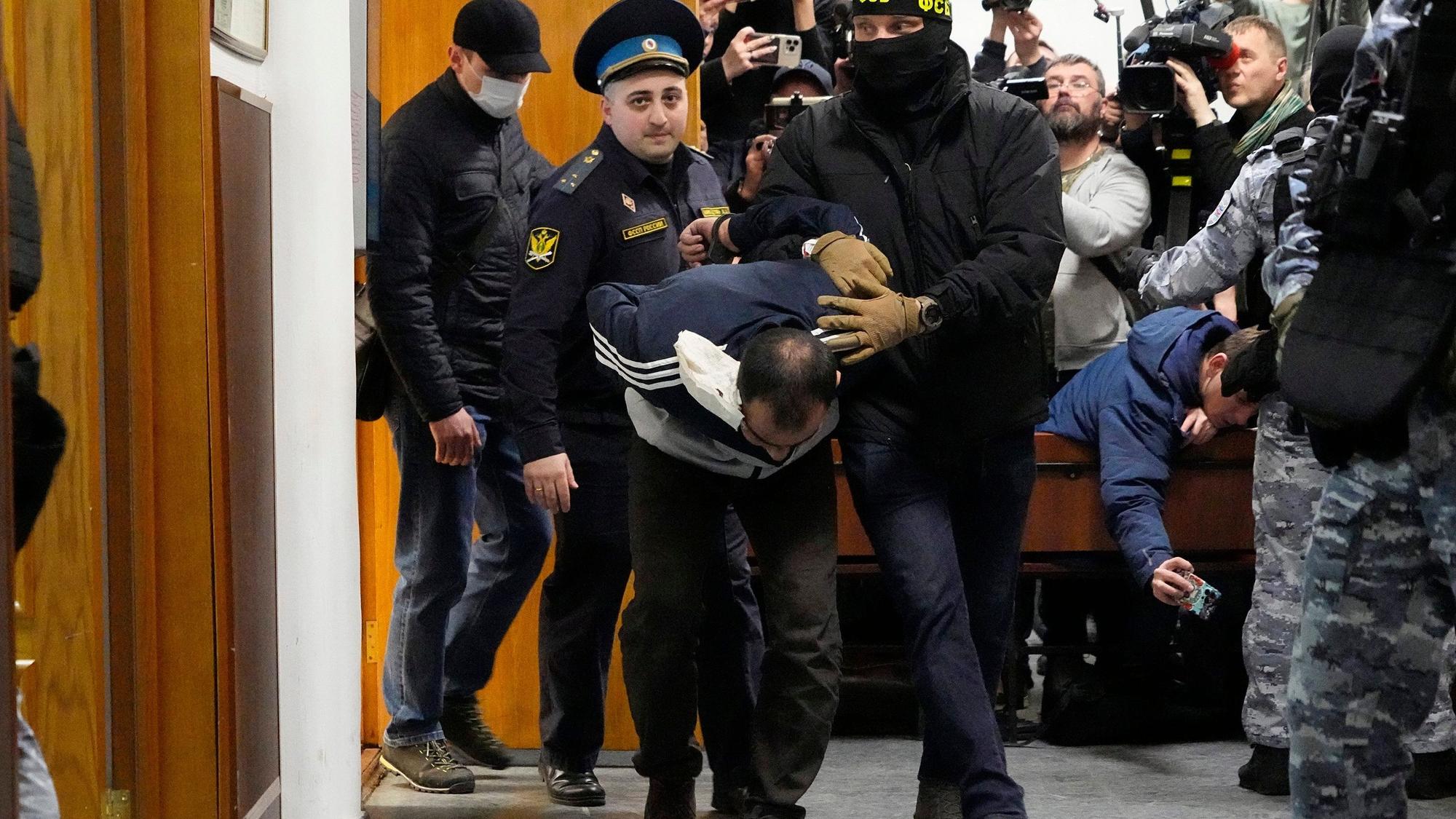 Ein Tatverdächtiger des Terroranschlags auf die Konzerthalle Crocus City Hall wird von Polizisten und FSB-Beamten im Basmanny-Bezirksgericht eskortiert.