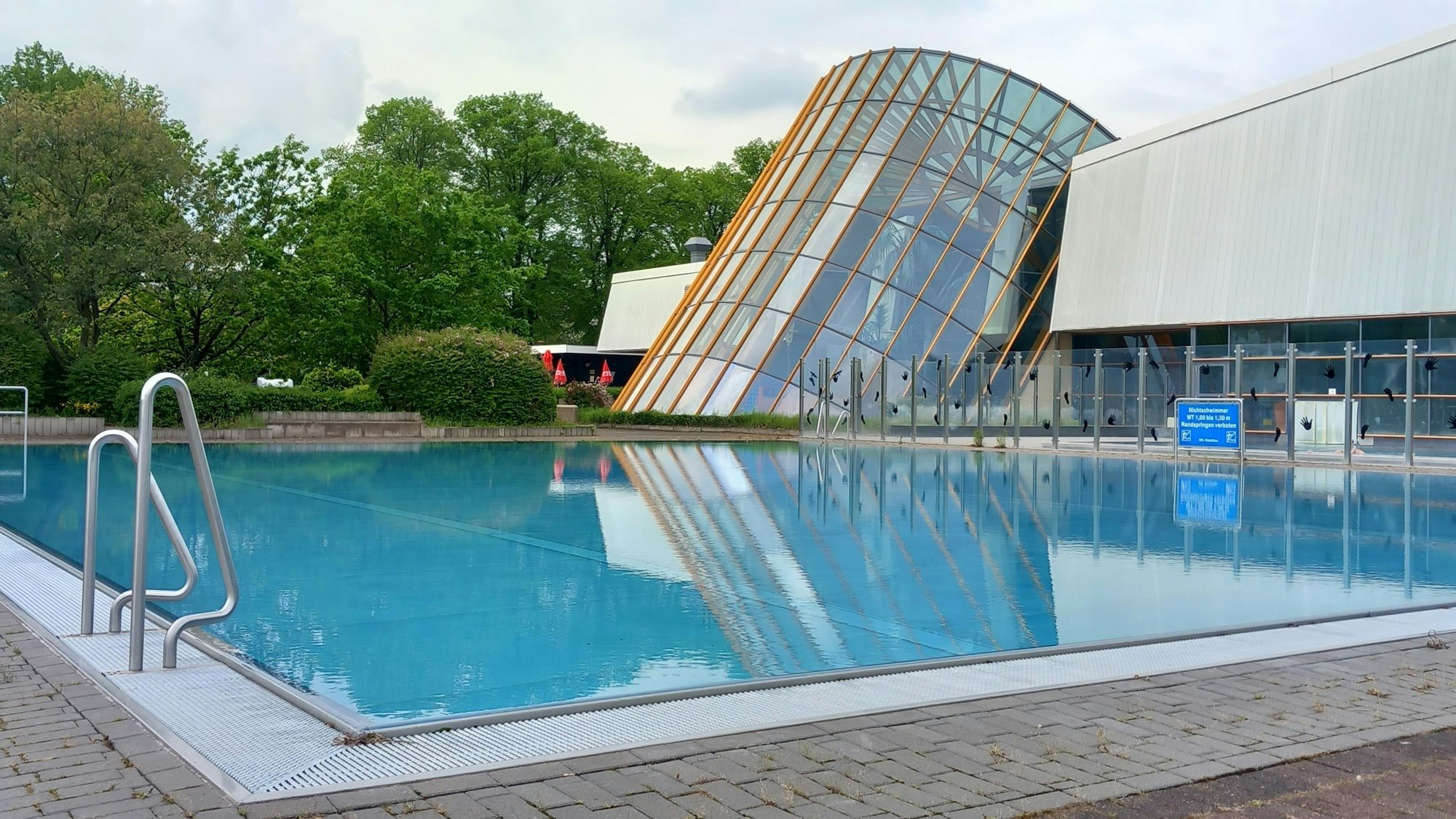 Blick auf das Außenschwimmbecken und den Glasturm