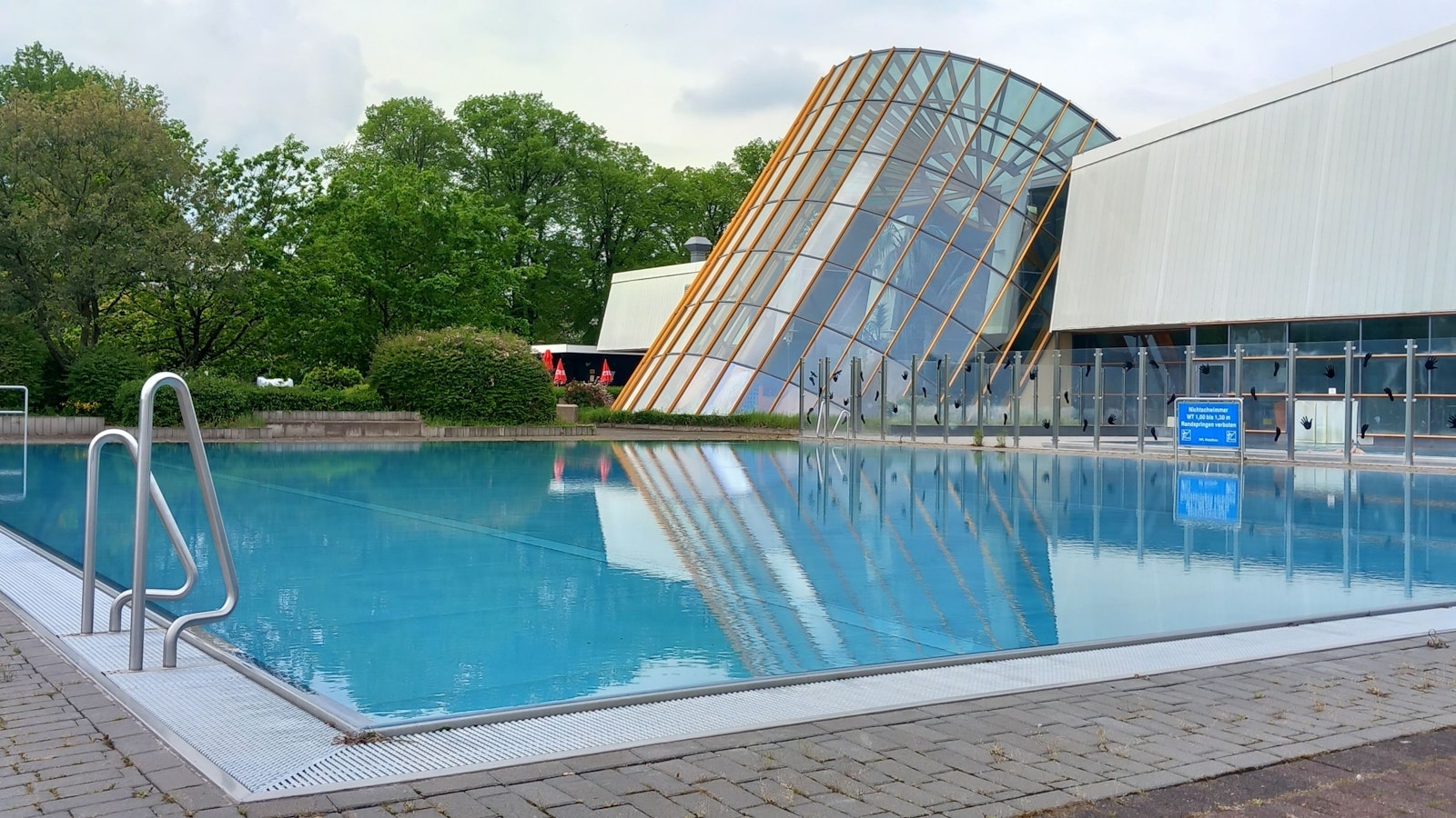 Blick auf das Außenschwimmbecken und den Glasturm