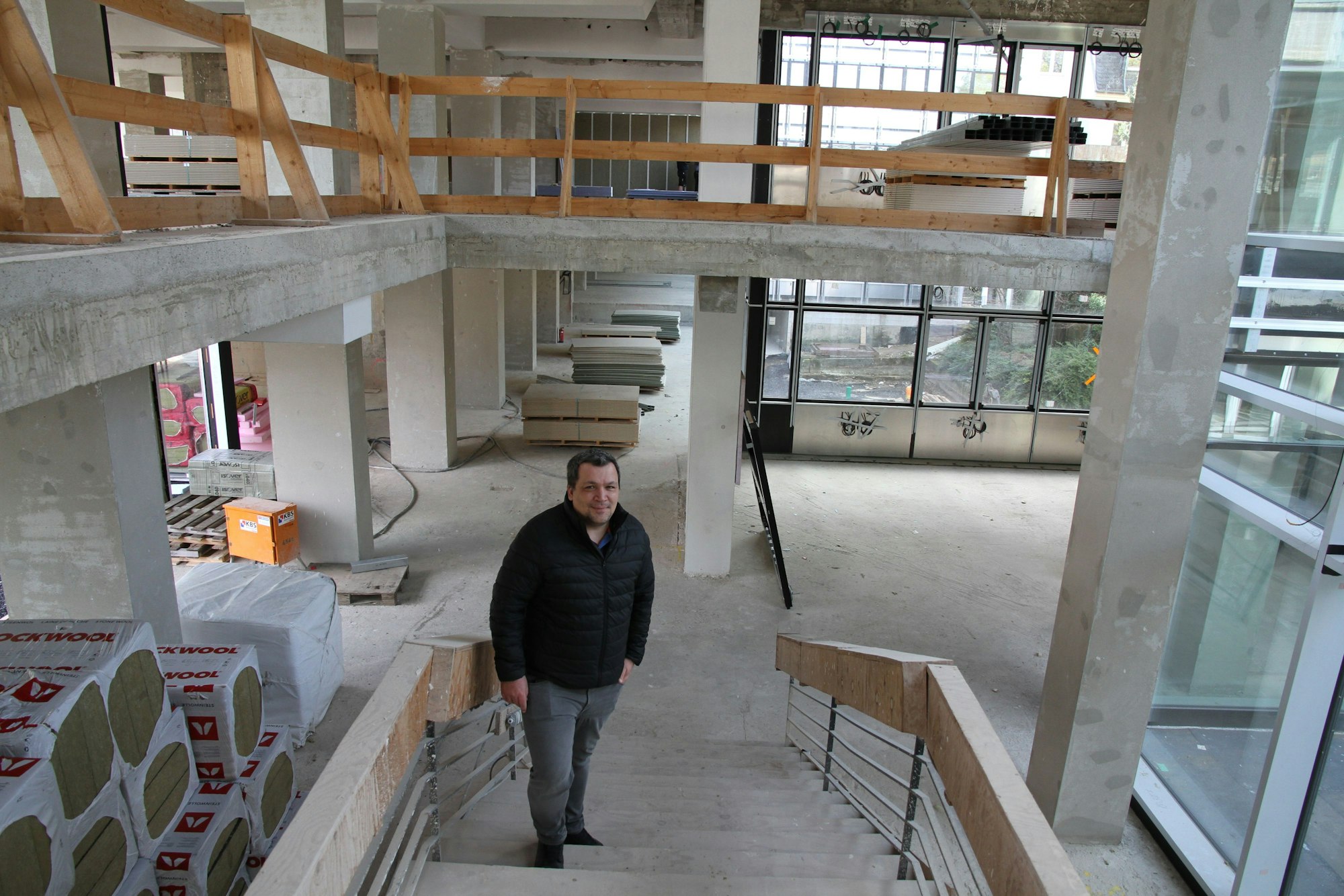 Ein Mann steht in einem Treppenhaus, das gerade saniert wird