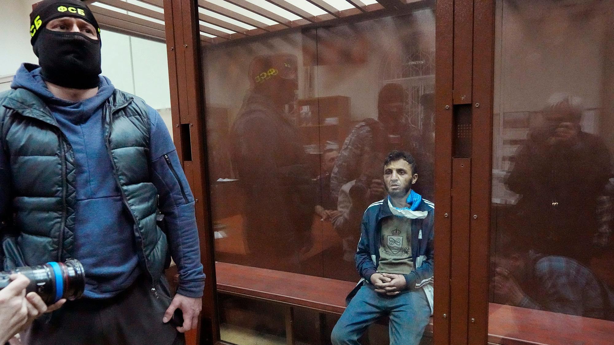 Moskau: Ein Tatverdächtiger des Terroranschlags auf die Konzerthalle Crocus City Hall sitzt in einem Glaskäfig im Bezirksgericht Basmanny. Auf der Mütze des Sicherheitsmanns steht auf kyrillisch FSB, die Abkürzung für den russischen Inlandsgeheimdienst.