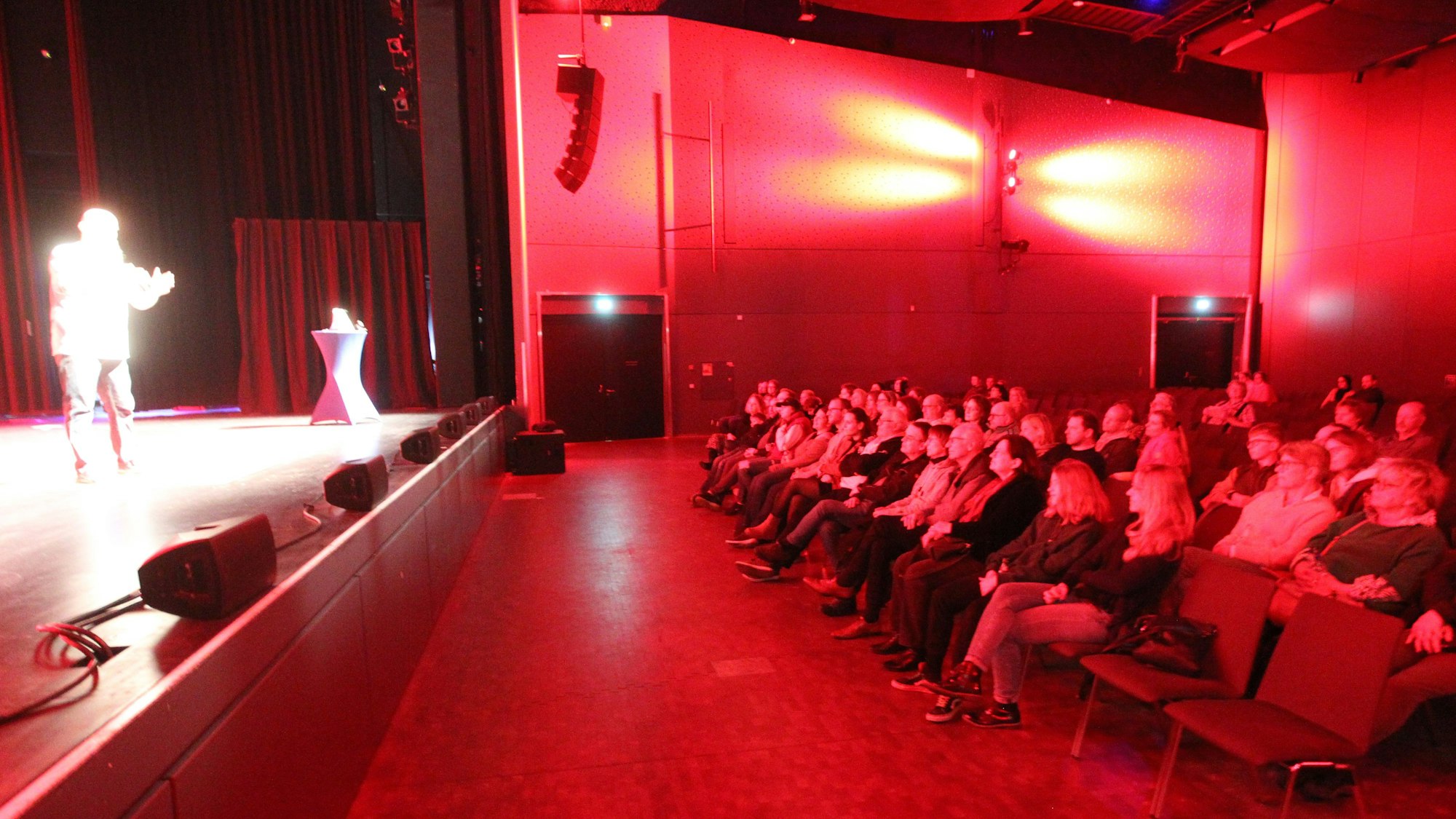 Ein Blick in den Saal der Troisdorfer Stadthalle mit nicht vollbesetzten Stuhlreihen und dem Hunde-Experten Holger Schüler auf der Bühne.