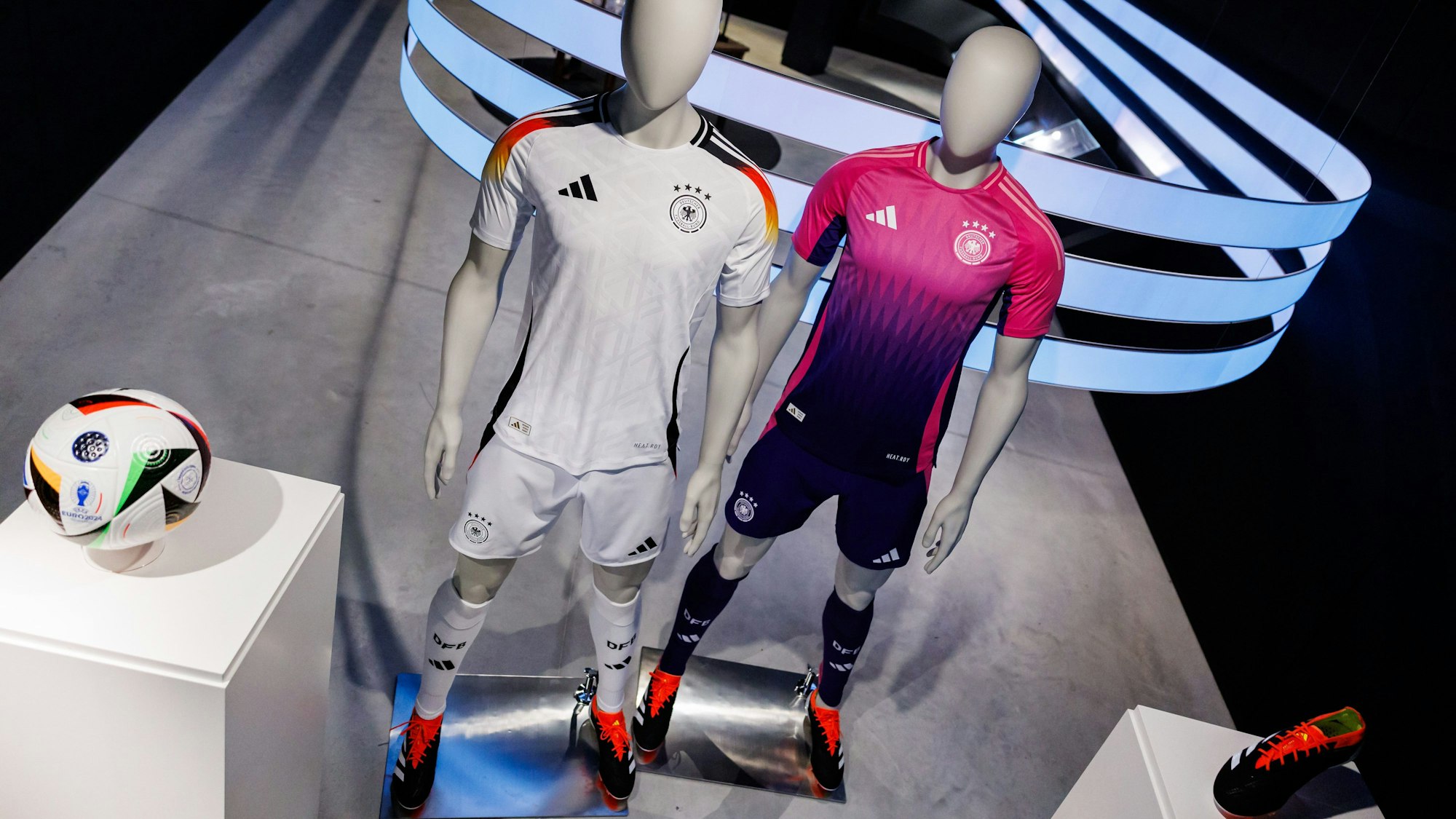 Die offiziellen Trikots der deutschen Fußball-Nationalmannschaft für die kommende Fußball-Europameisterschaft 2024 (UEFA EURO 2024) und der offizielle Spielball sind am Sitz des Sportartikelherstellers adidas AG zu sehen.
