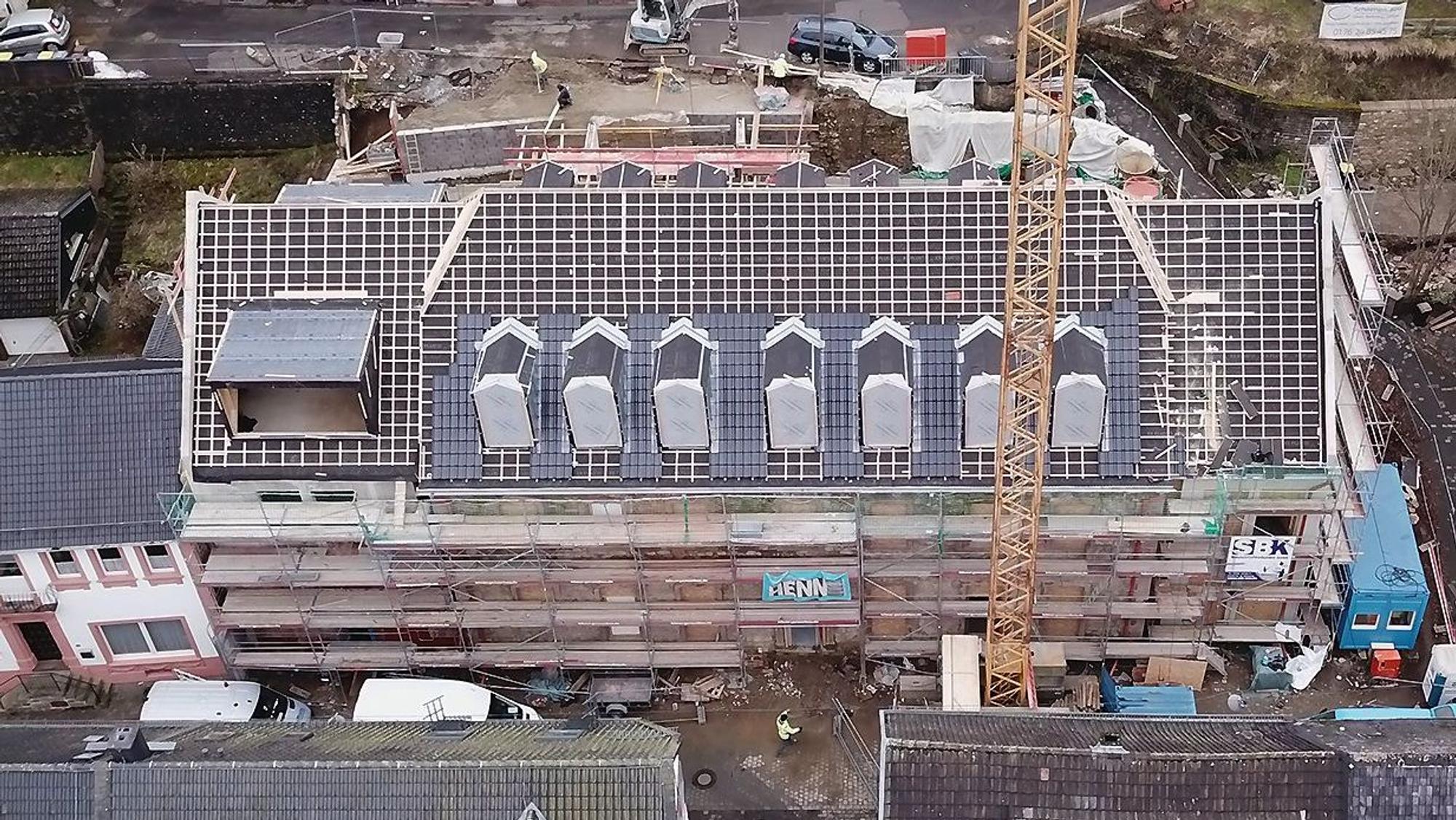 Das Luftbild zeigt das historische Gebäude an der Blankenheimer Ahrstraße. Das Haus ist eingerüstet, das Dach ist abgedeckt.
